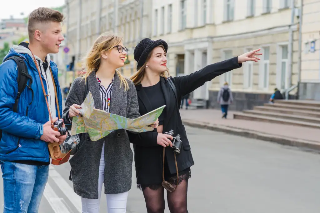 What Does a Tourist Guide Do Tourist guide showing visitors directions during a guided city tour in the UK