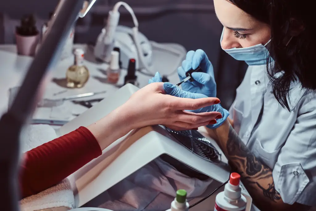 nail technician working with client