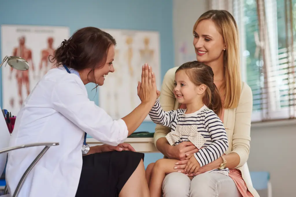 Occupational therapist high-fiving a young patient
